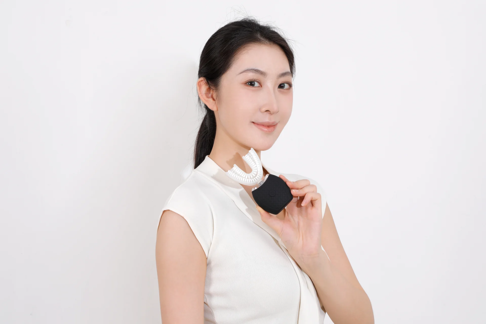 Woman holding a black compact TB-01 toothbrush