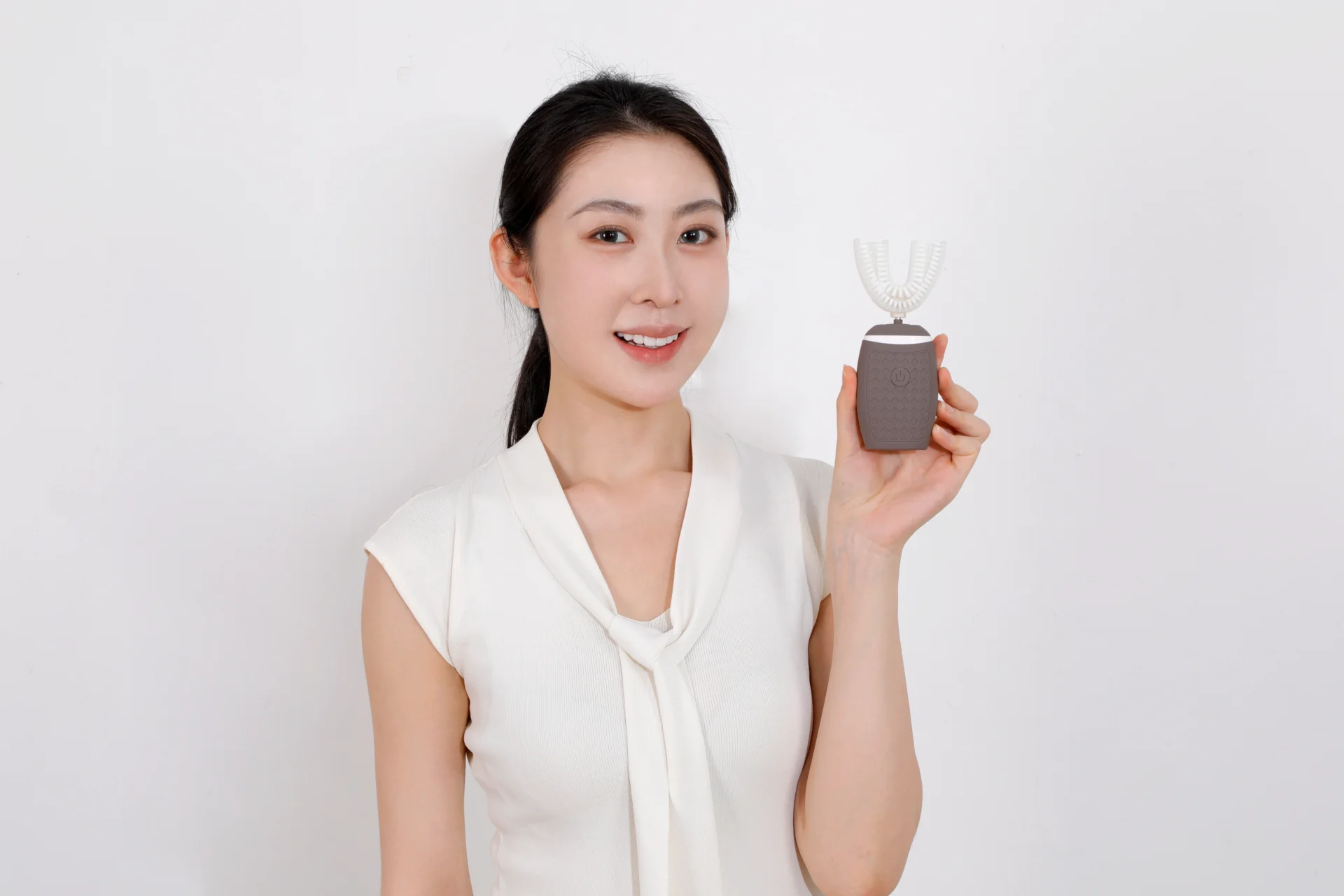 Woman holding a cocoa-colored compact TB-05 toothbrush
